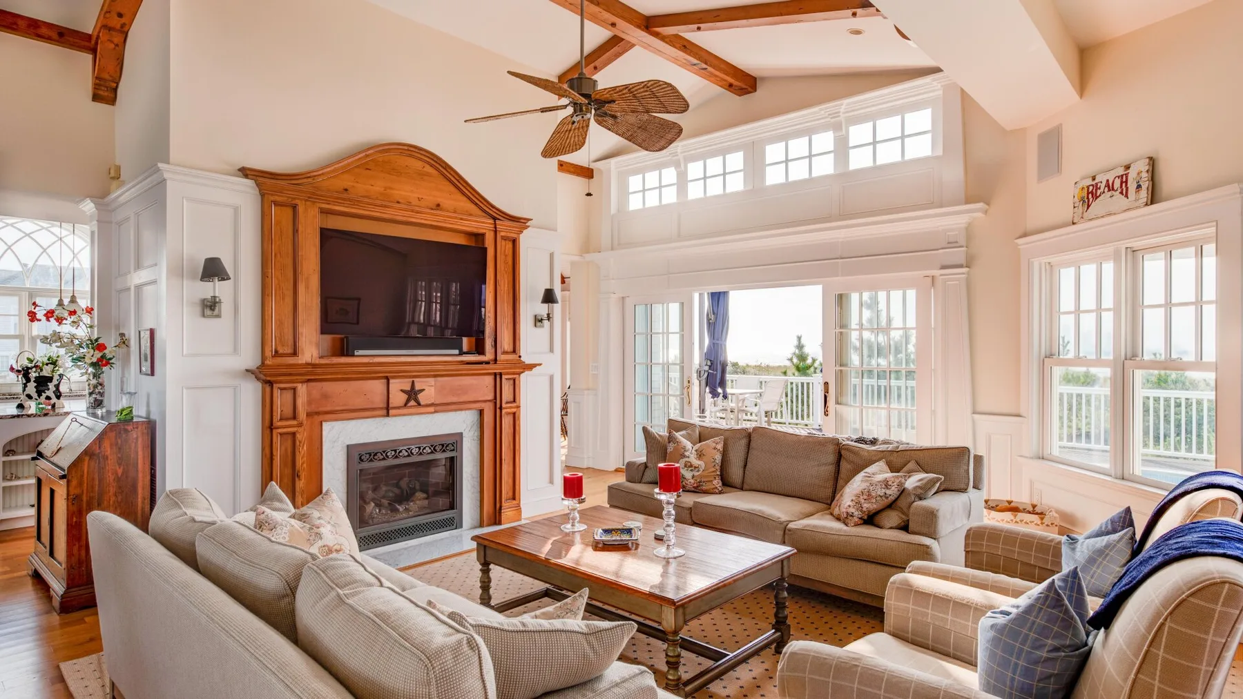 A bright living room with seating arranged around a coffee table and fireplace.