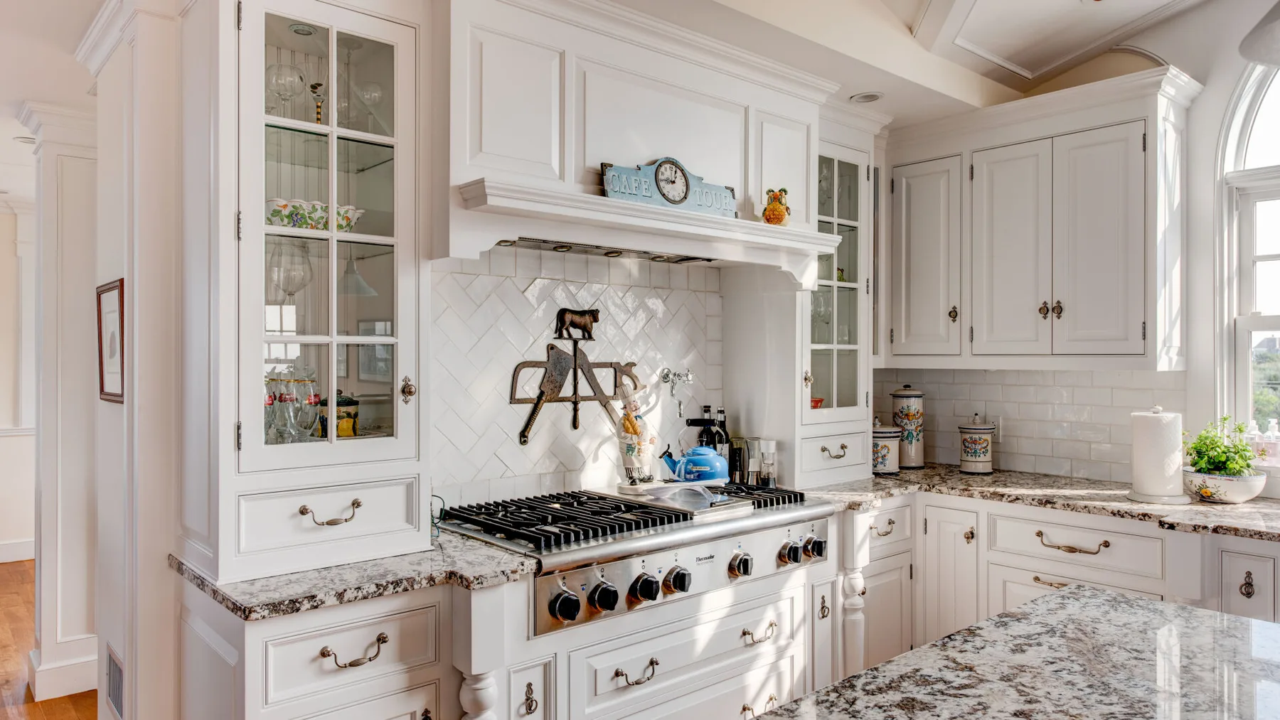 Una cocina luminosa con gabinetes blancos y una amplia estufa.
