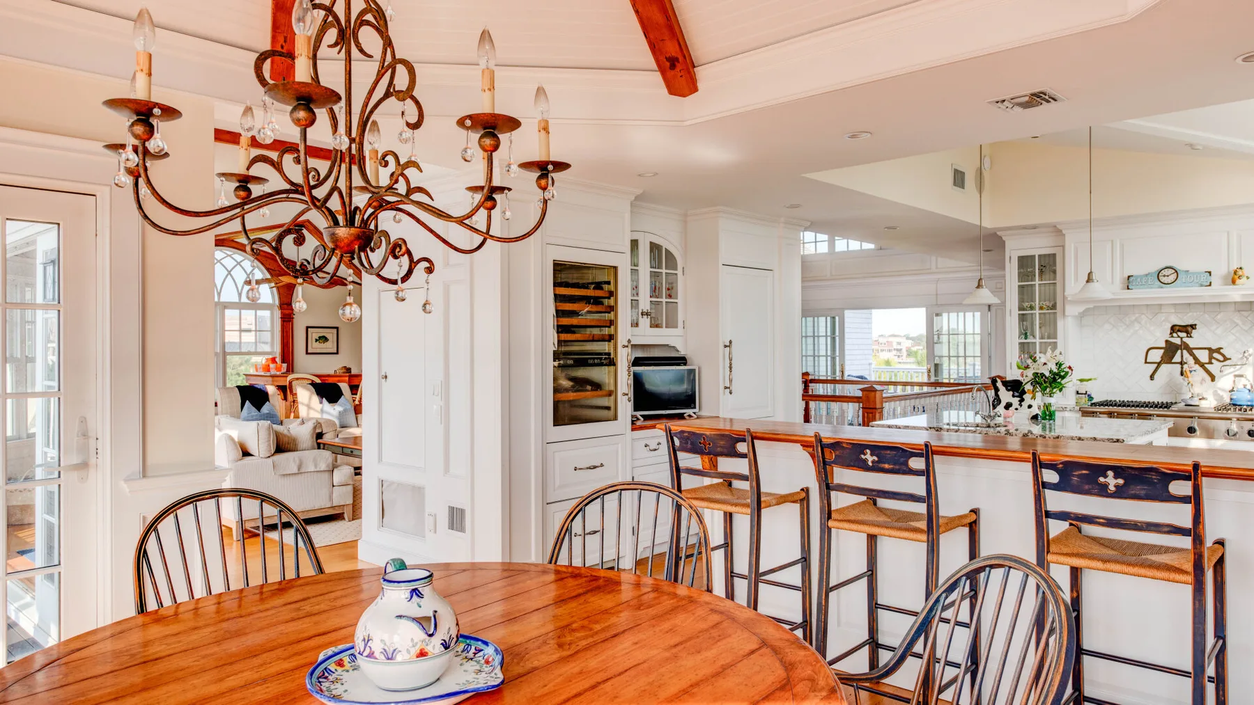 Una luminosa cocina-comedor de planta abierta con una mesa de madera y una barra.