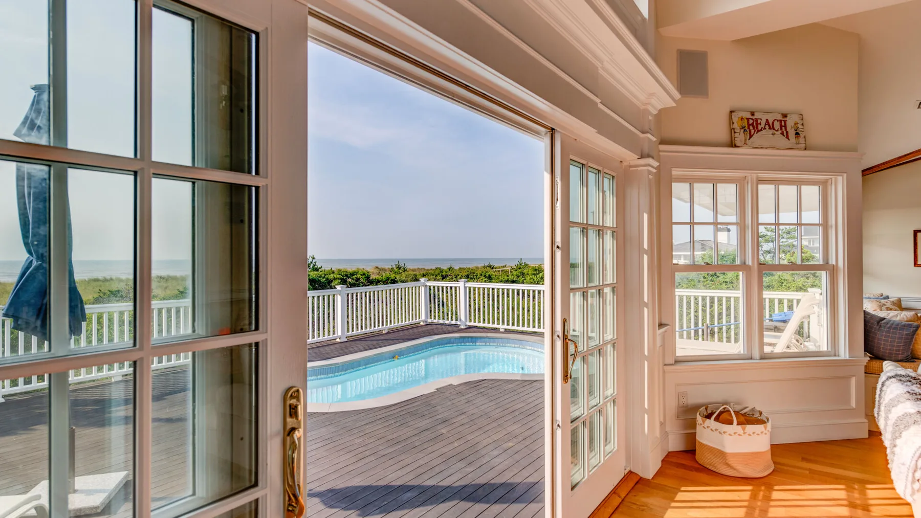 Un dormitorio luminoso da a una terraza con piscina y vistas al mar.