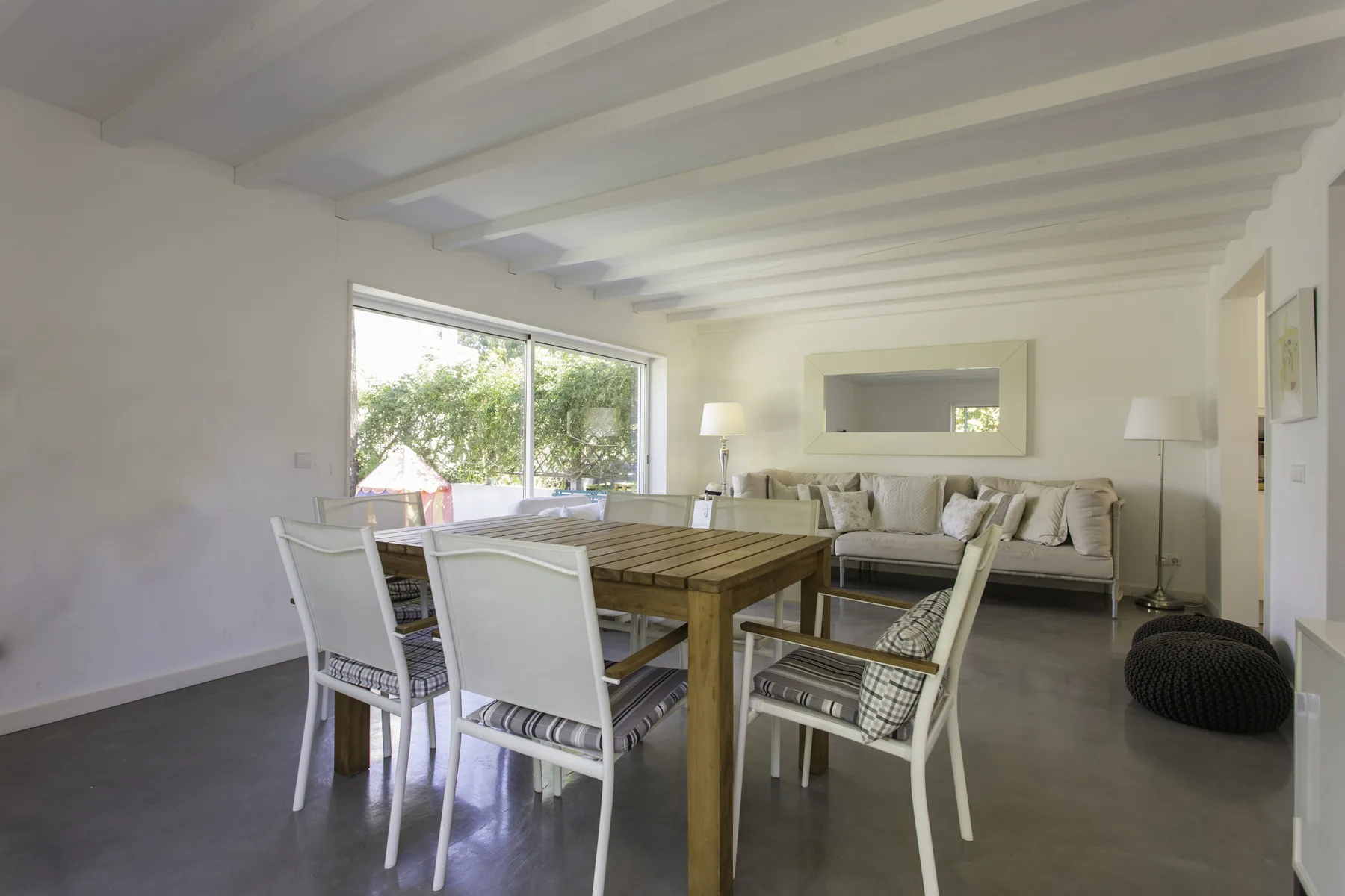 Una luminosa sala de estar y comedor con una mesa de madera y asientos.