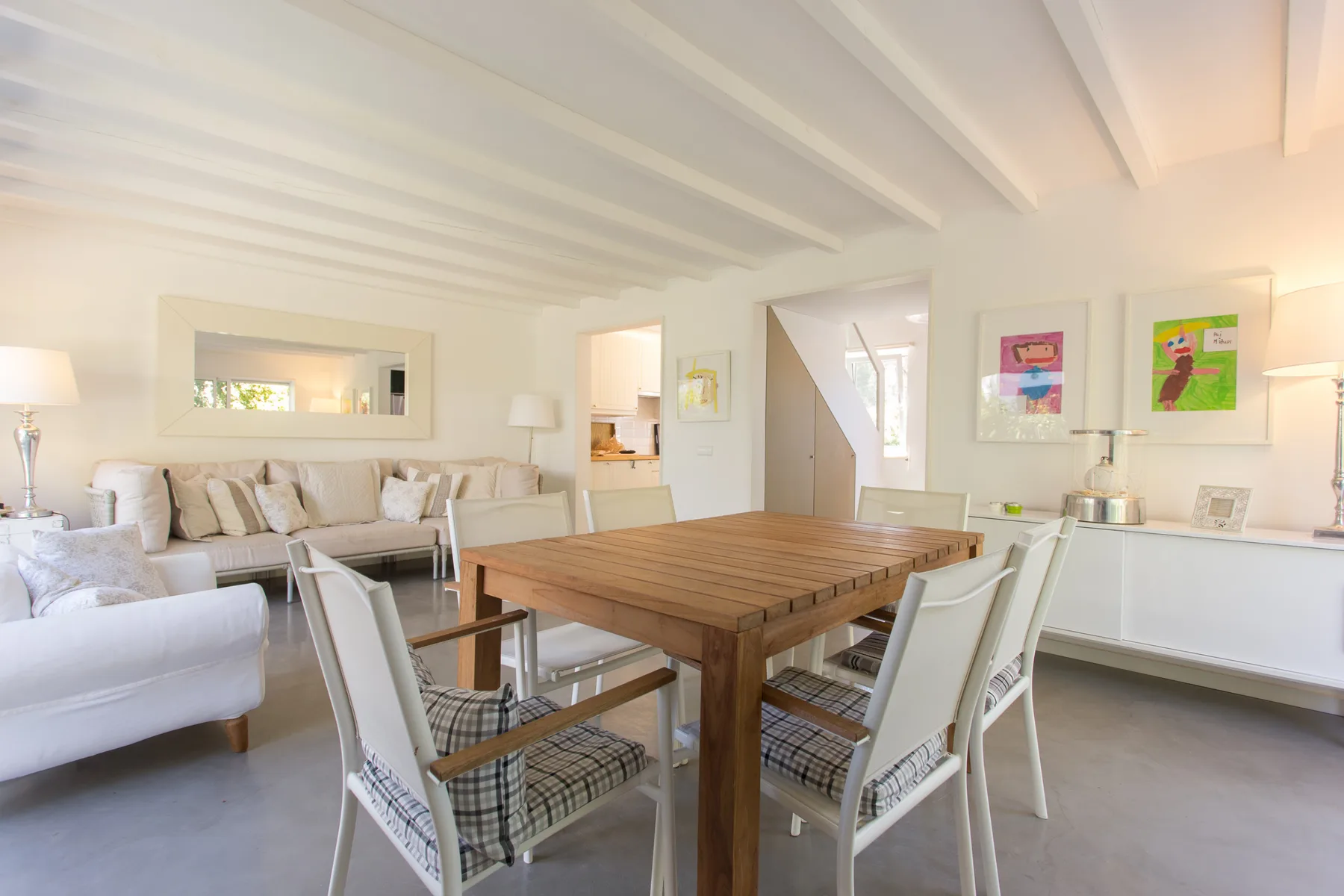 Una luminosa sala de estar y comedor con una mesa de madera y asientos.