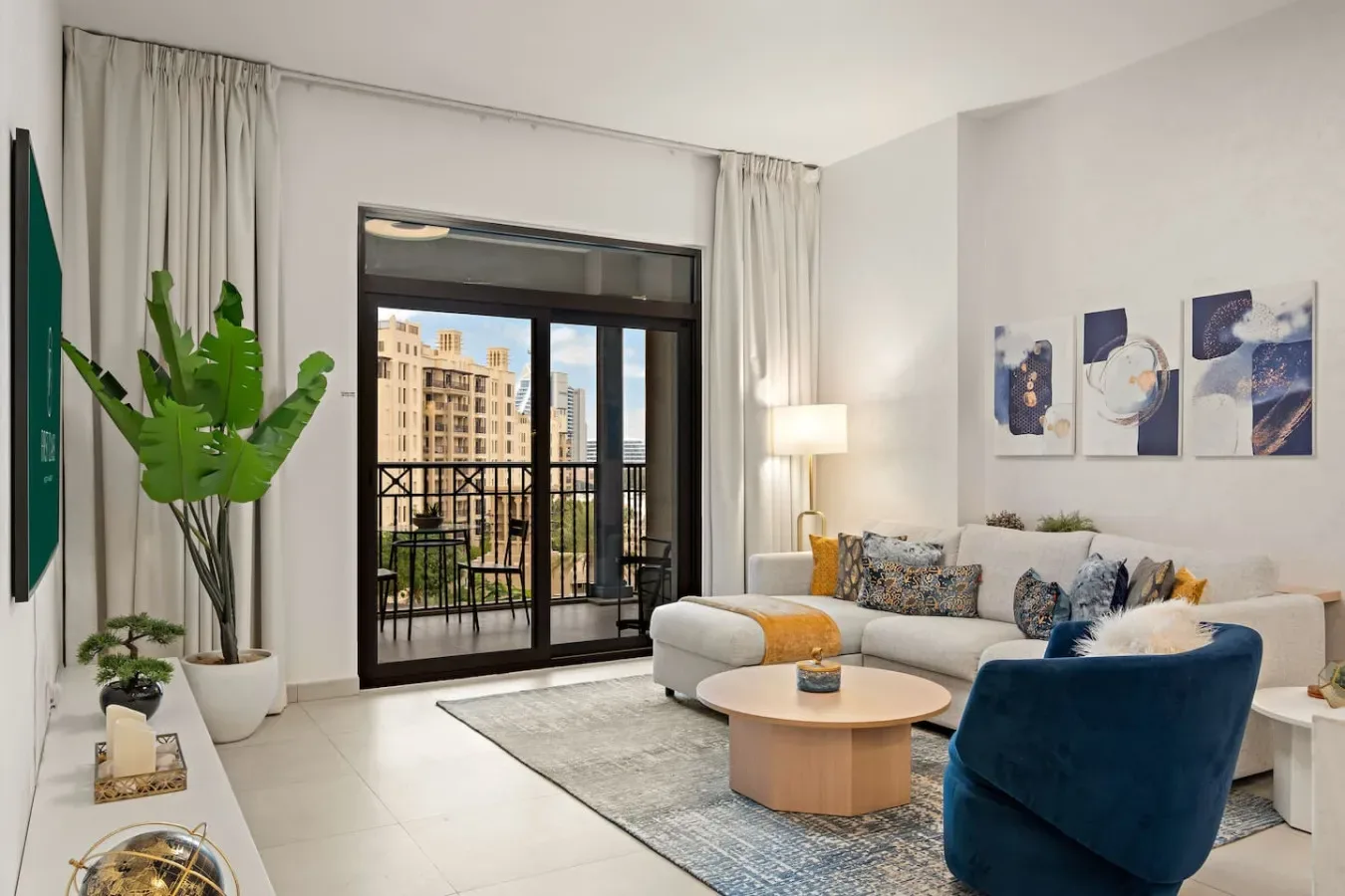 Una sala luminosa con una zona de estar junto a puertas de vidrio y un balcón.
