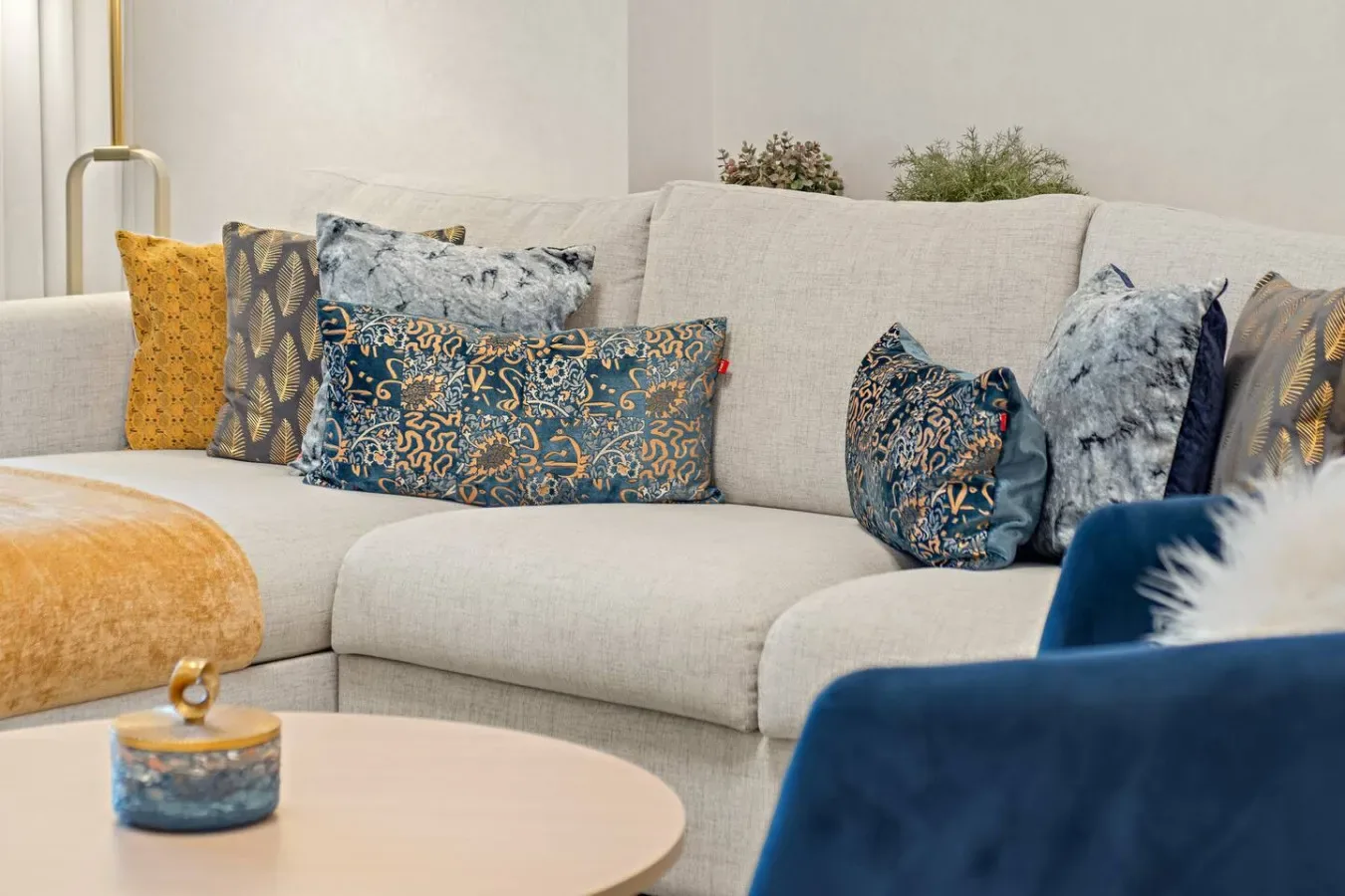 A living room seating area with a light-colored sofa and patterned cushions.
