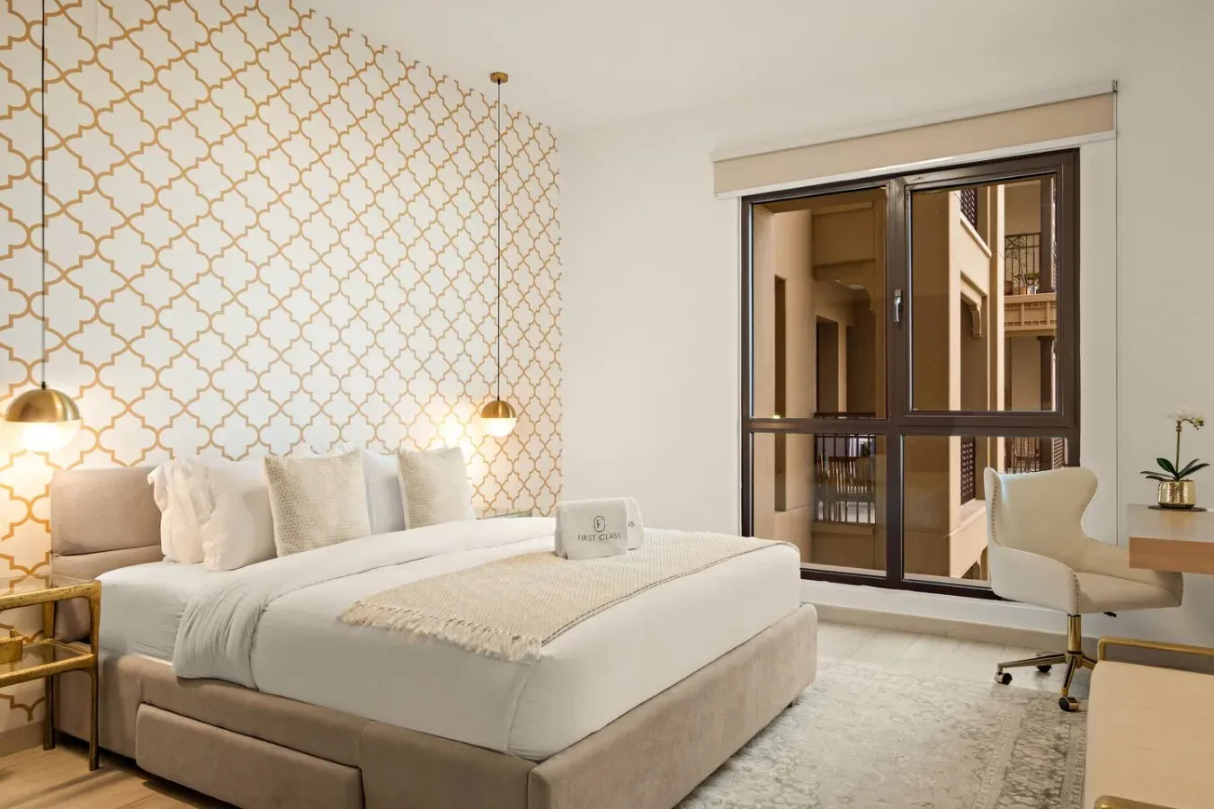 Un dormitorio con una cama grande junto a una ventana y un escritorio.