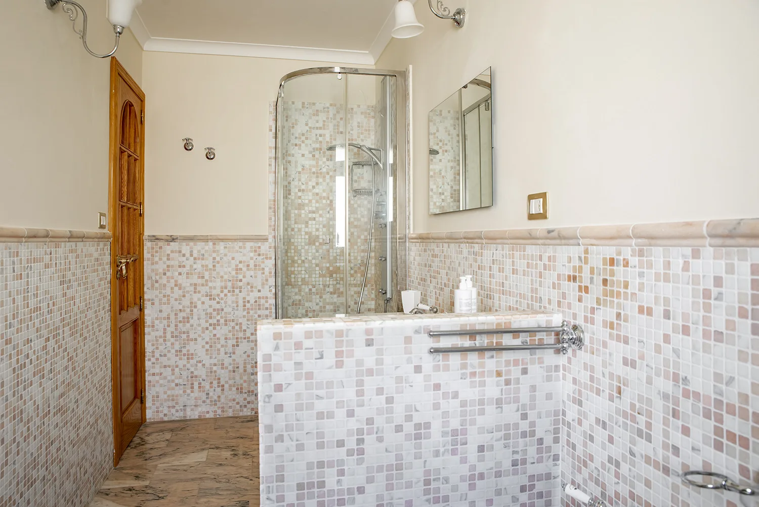 Un baño alicatado con bañera y ducha de vidrio.