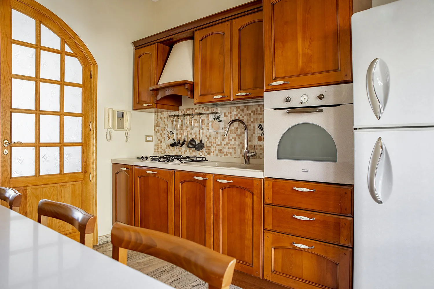 Una cocina con armarios de madera, una encimera y electrodomésticos integrados.