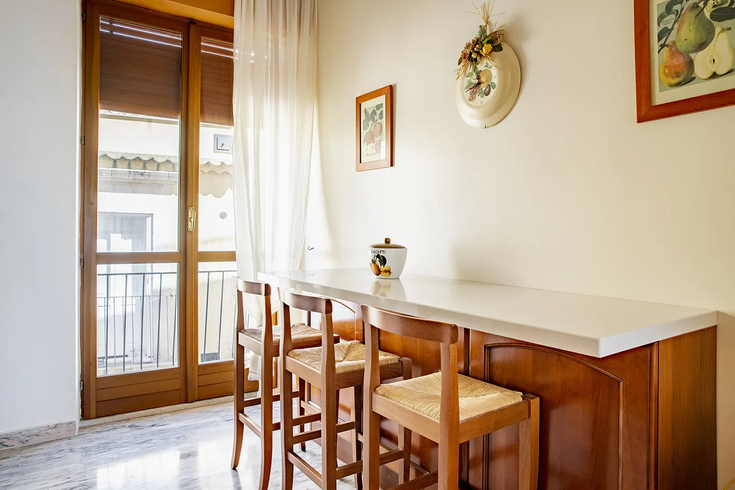 Comedor con una mesa larga y asientos de madera junto a una puerta acristalada.