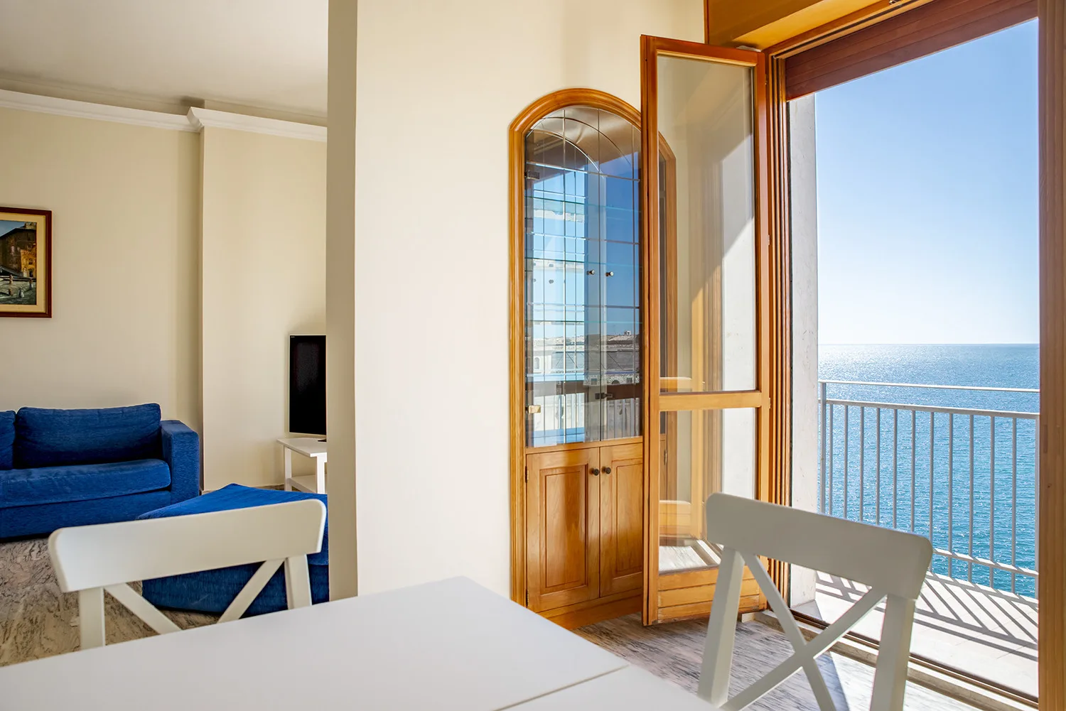 Un comedor da a un balcón con vistas al mar.