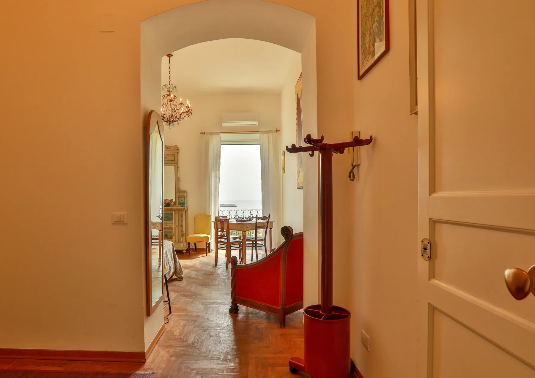 An arched doorway opens onto a dining area with a table and chairs.