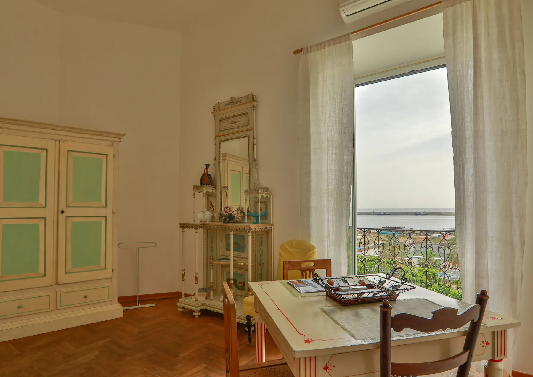 A dining area with a table beside tall curtains and a balcony window.