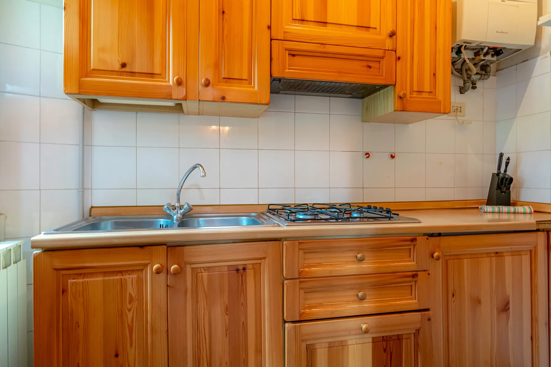 Una cocina con gabinetes de madera, un fregadero y una estufa.