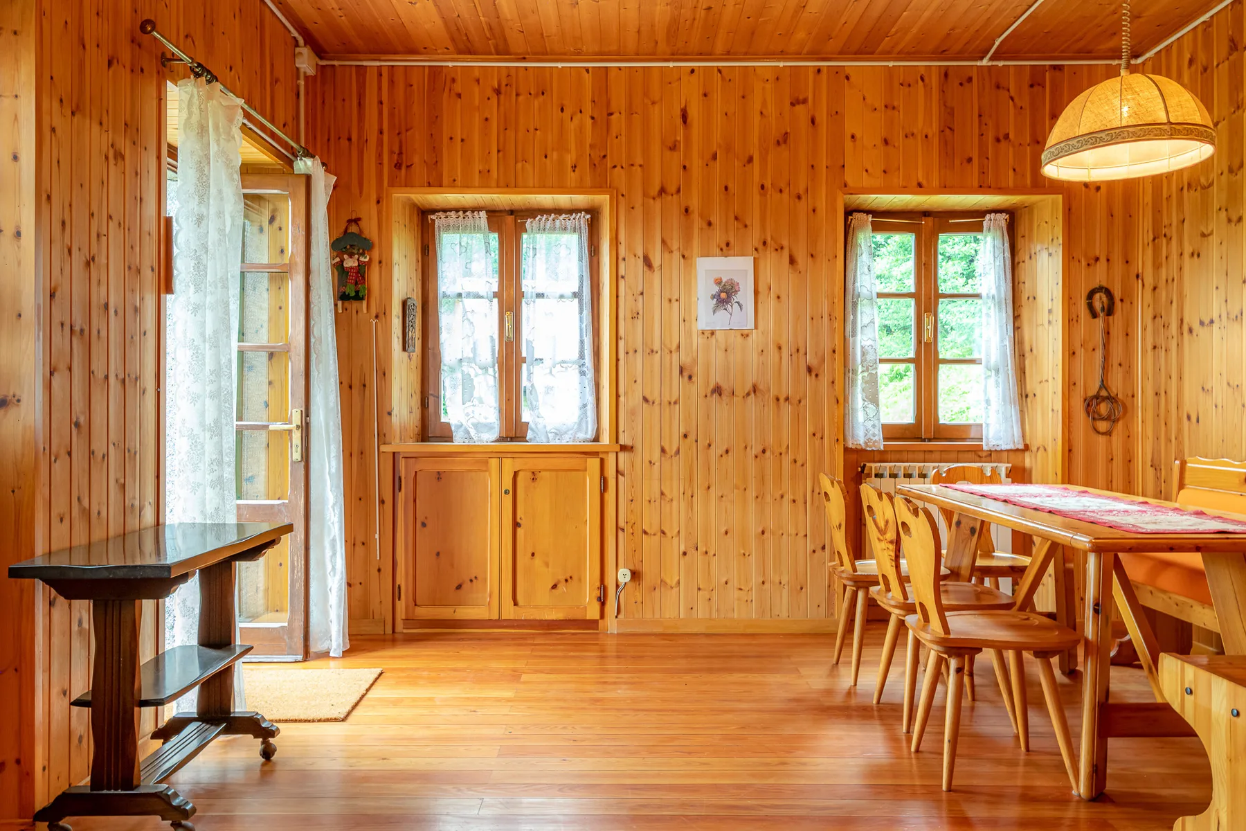 Un comedor con paredes de madera, una mesa larga y varias sillas.