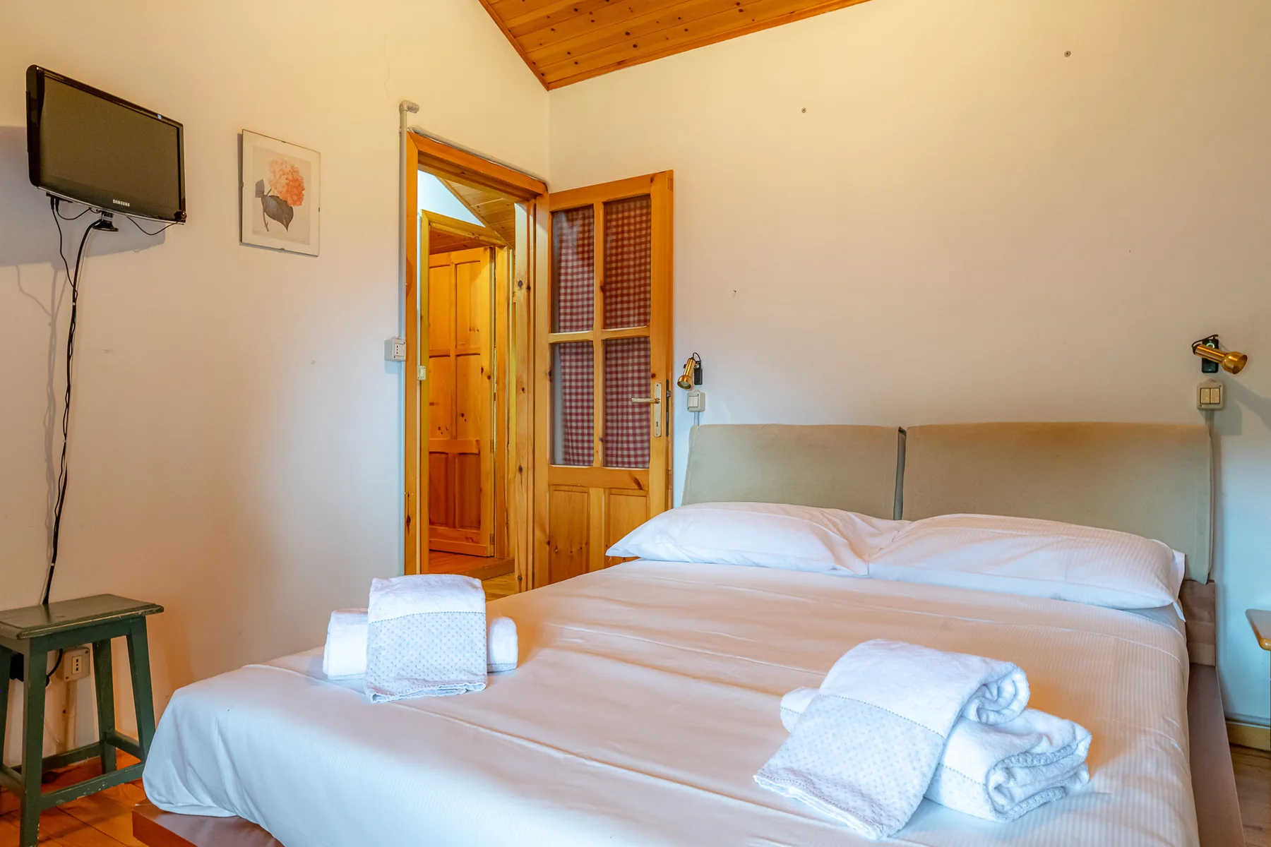 Un dormitorio con una cama bien hecha y toallas dobladas.