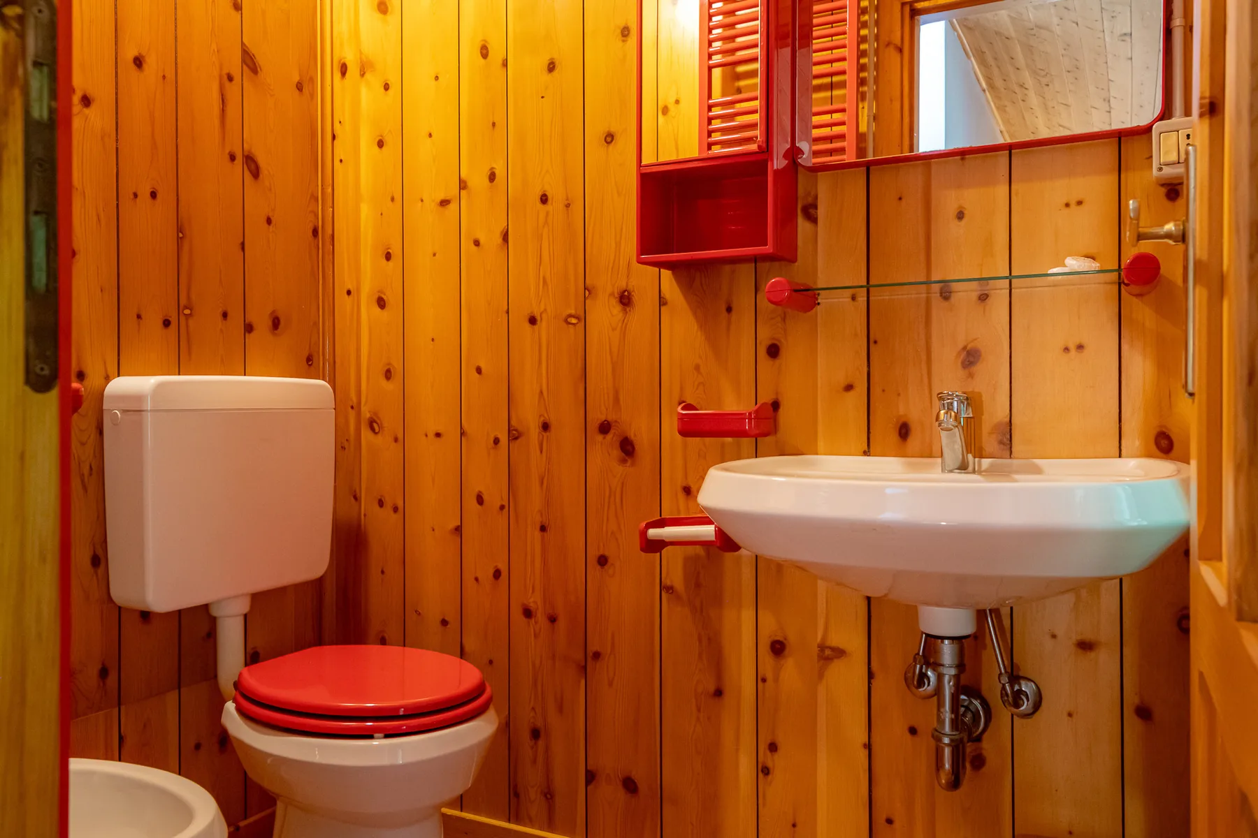 Un baño pequeño con inodoro y lavabo montado en la pared.