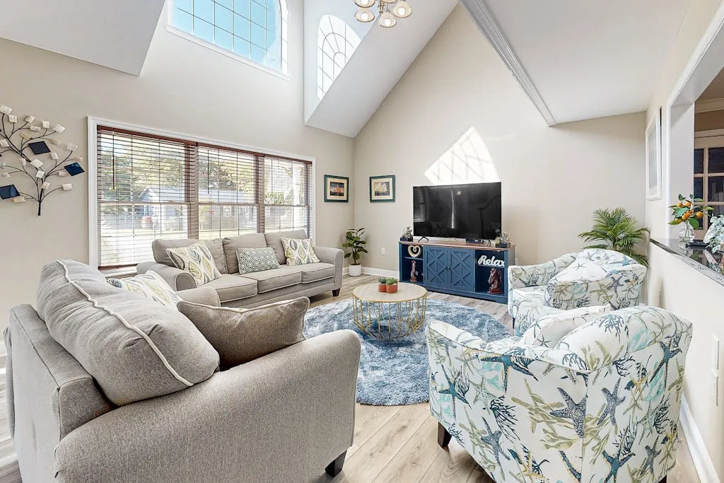 A bright living room with seating arranged around a television and coffee table.
