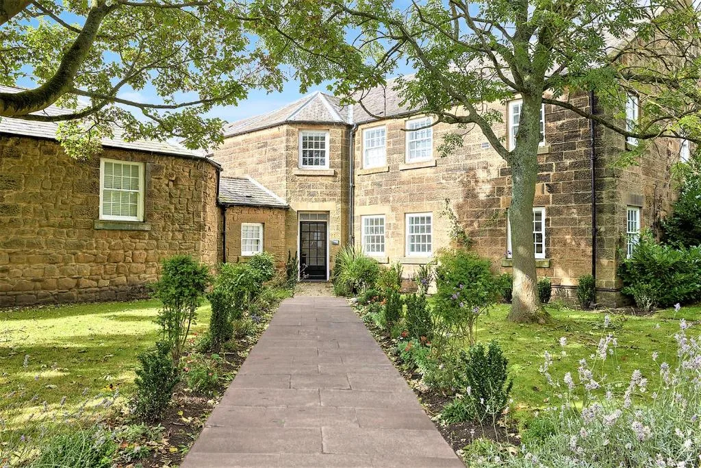 A stone building stands at the end of a garden path.