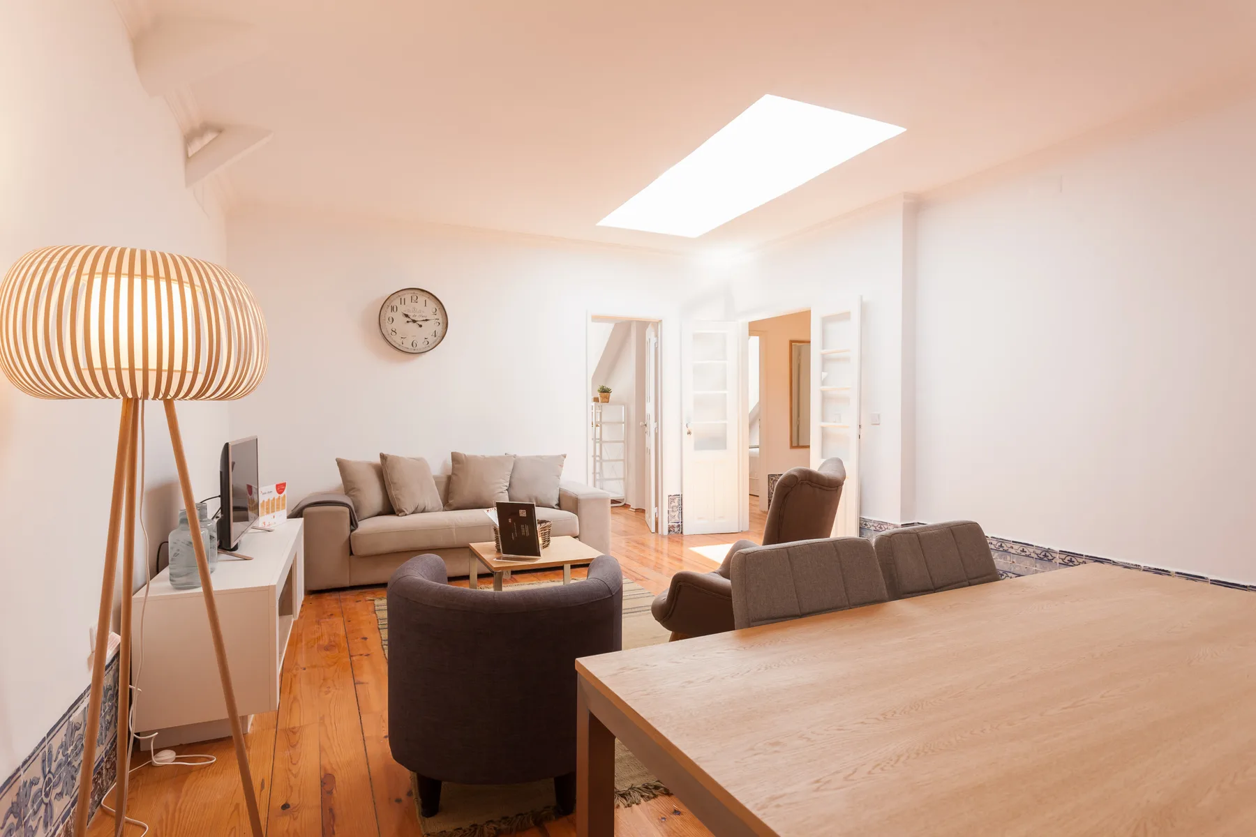 A living room with seating, a coffee table, and a large dining table.