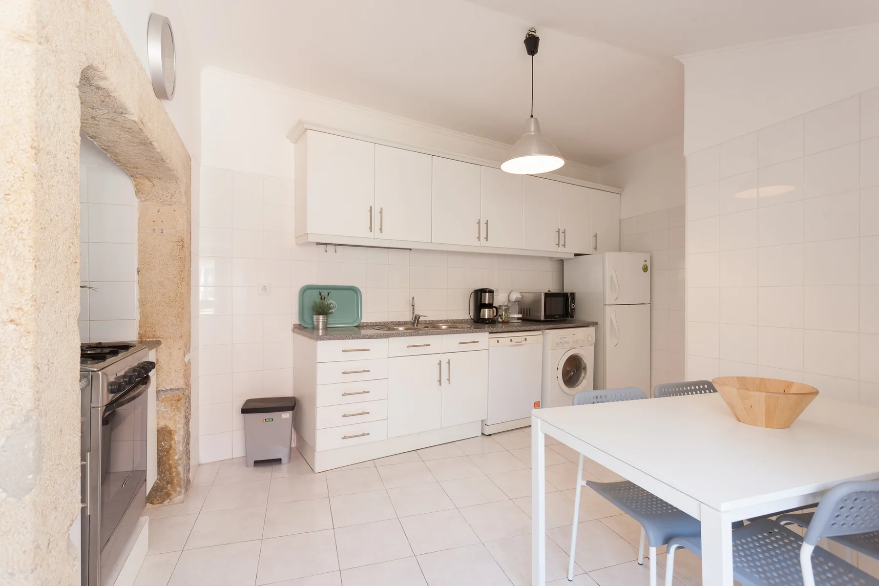 A bright kitchen and dining area with white cabinets and a table.