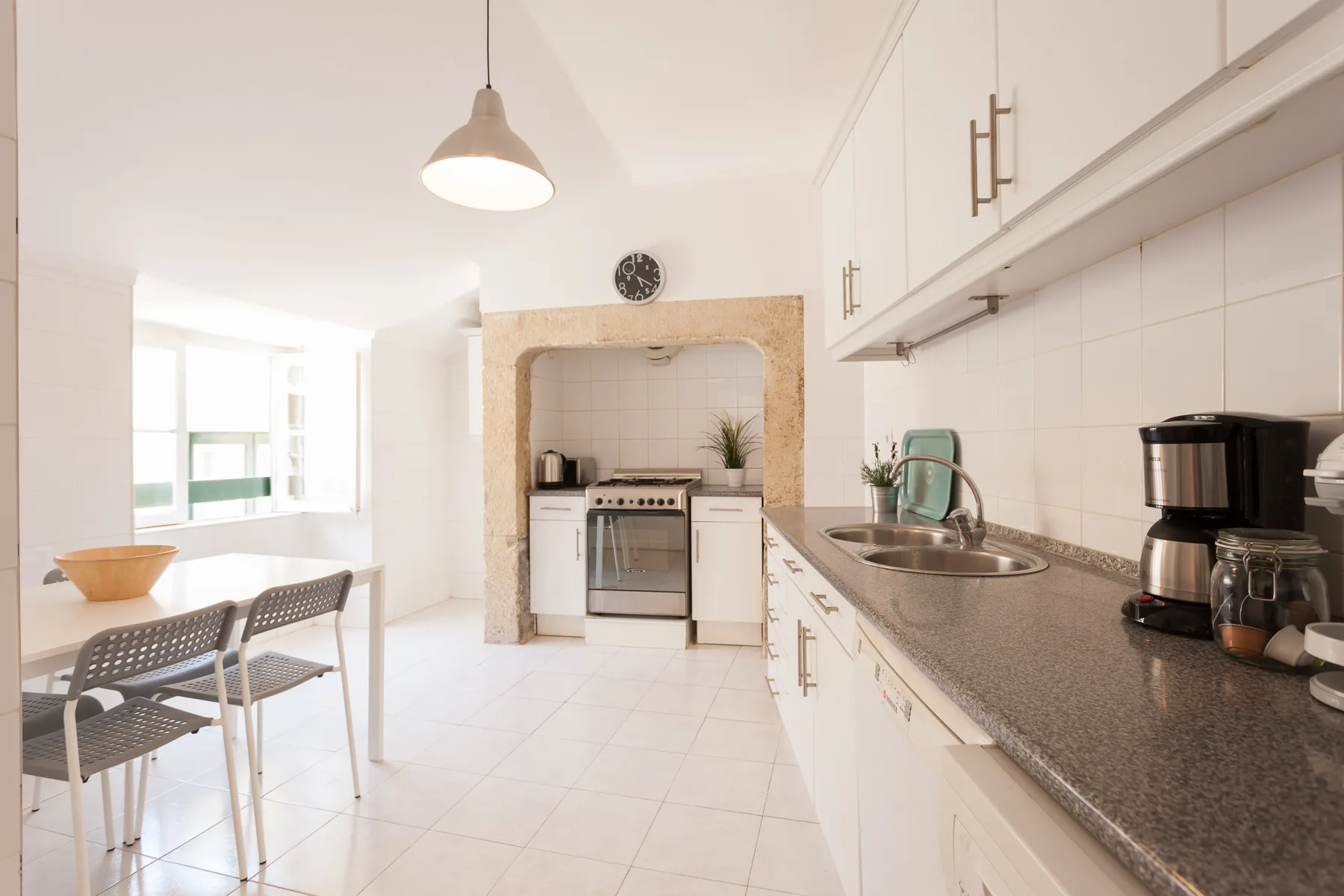 A bright kitchen with a dining table and countertop appliances.