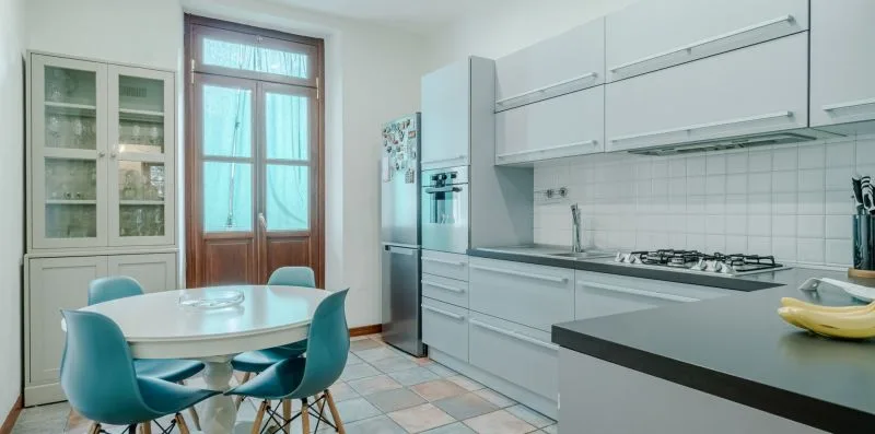 Una cocina luminosa con una mesa de comedor y gabinetes blancos.