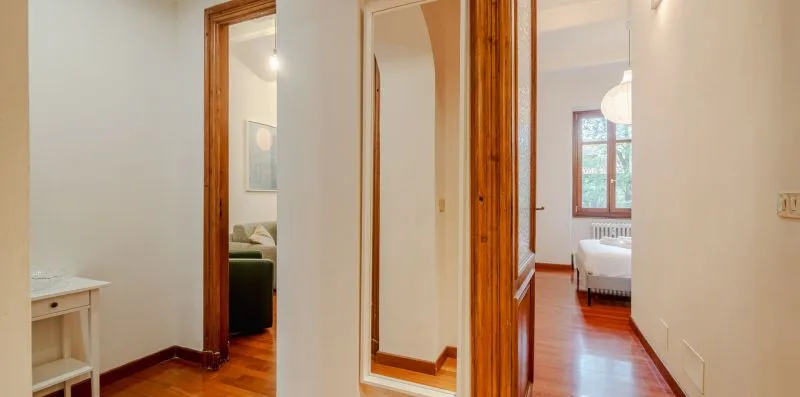 Un pasillo con puertas de madera da a habitaciones contiguas.