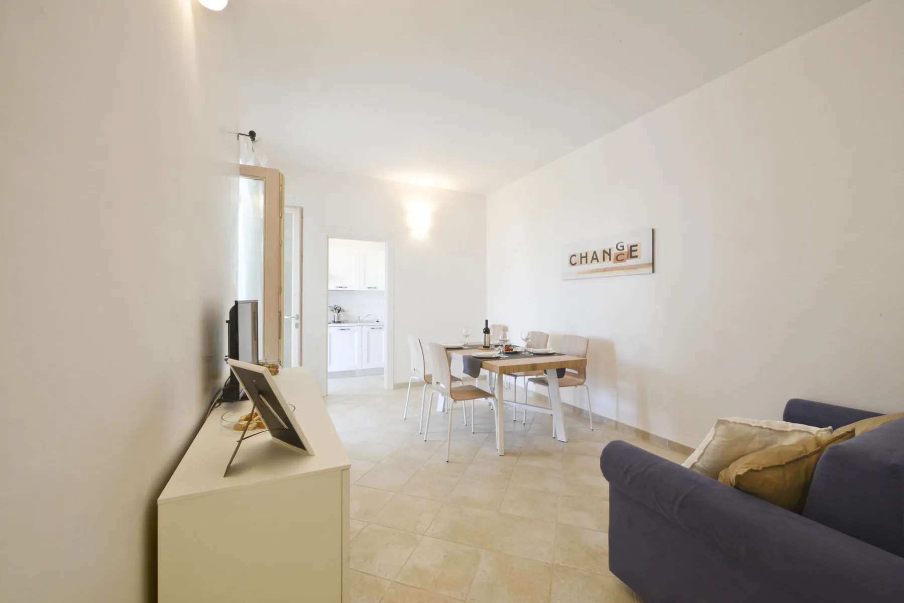 A bright living and dining area with a table and seating.