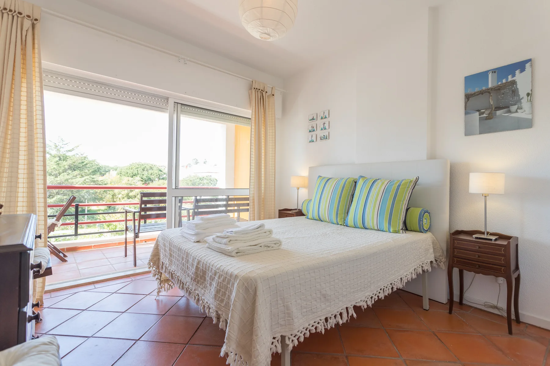 A bedroom with a double bed and sliding glass doors opening onto a balcony.