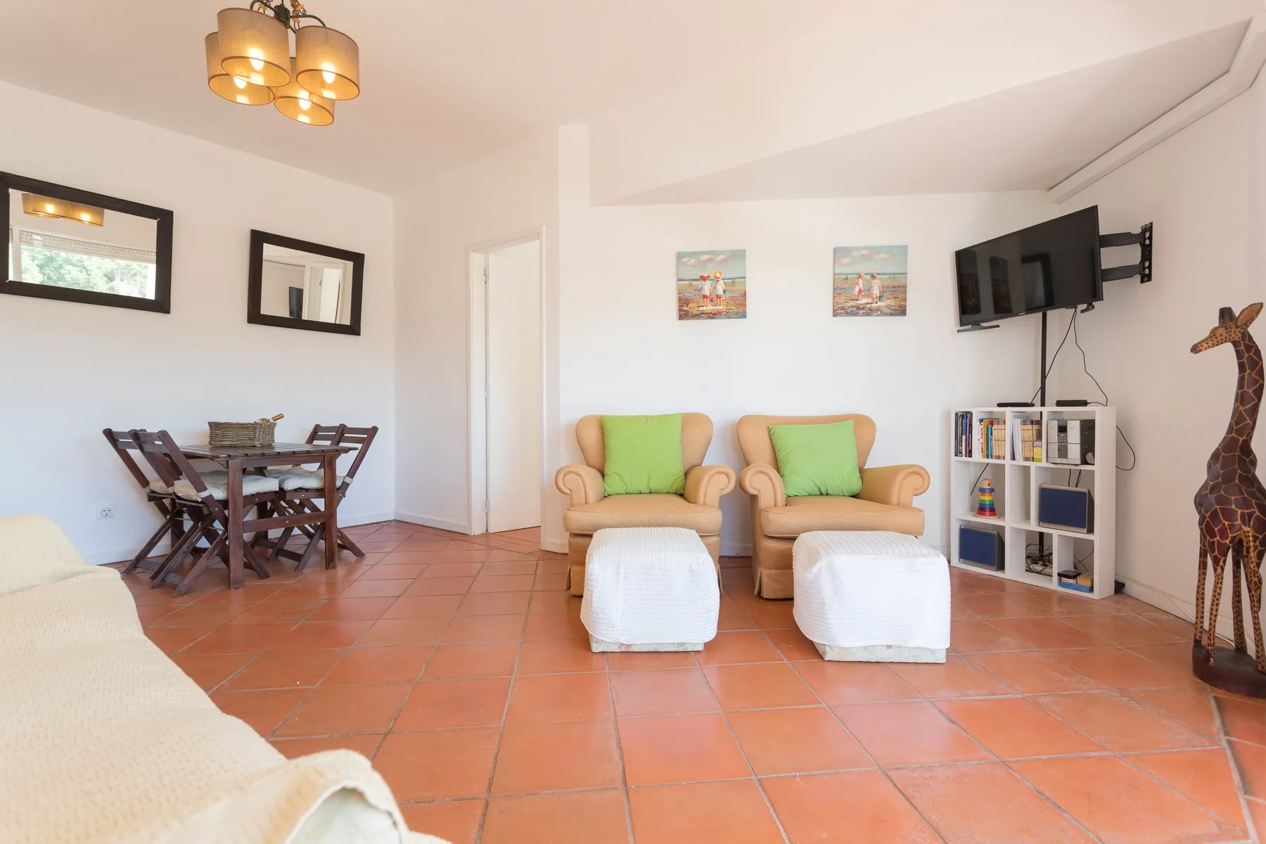 Una sala de estar con dos sillones, reposapiés y una mesa de comedor.
