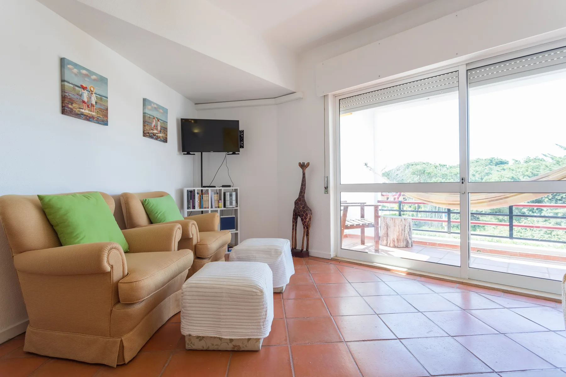 Sala de estar con asientos y puertas corredizas de vidrio que dan a un balcón.