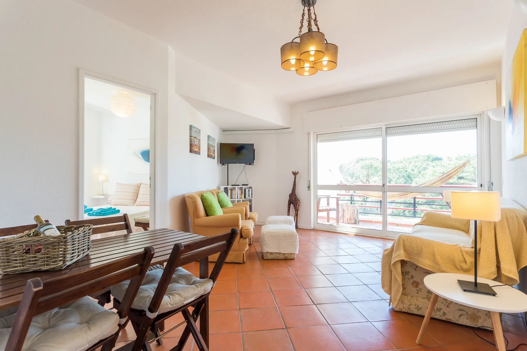 Una sala luminosa con asientos y grandes ventanas que dan a un balcón.