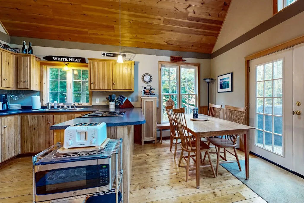 A rustic kitchen and dining area with wooden cabinets and a dining table.