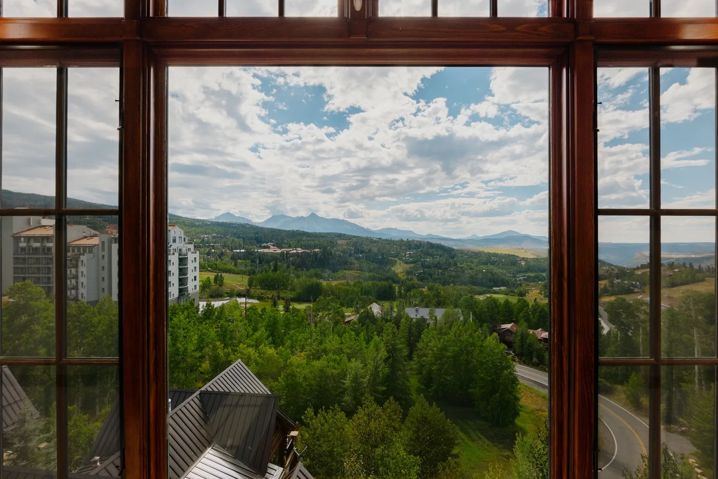 A broad green landscape and distant mountains are visible through a large window.