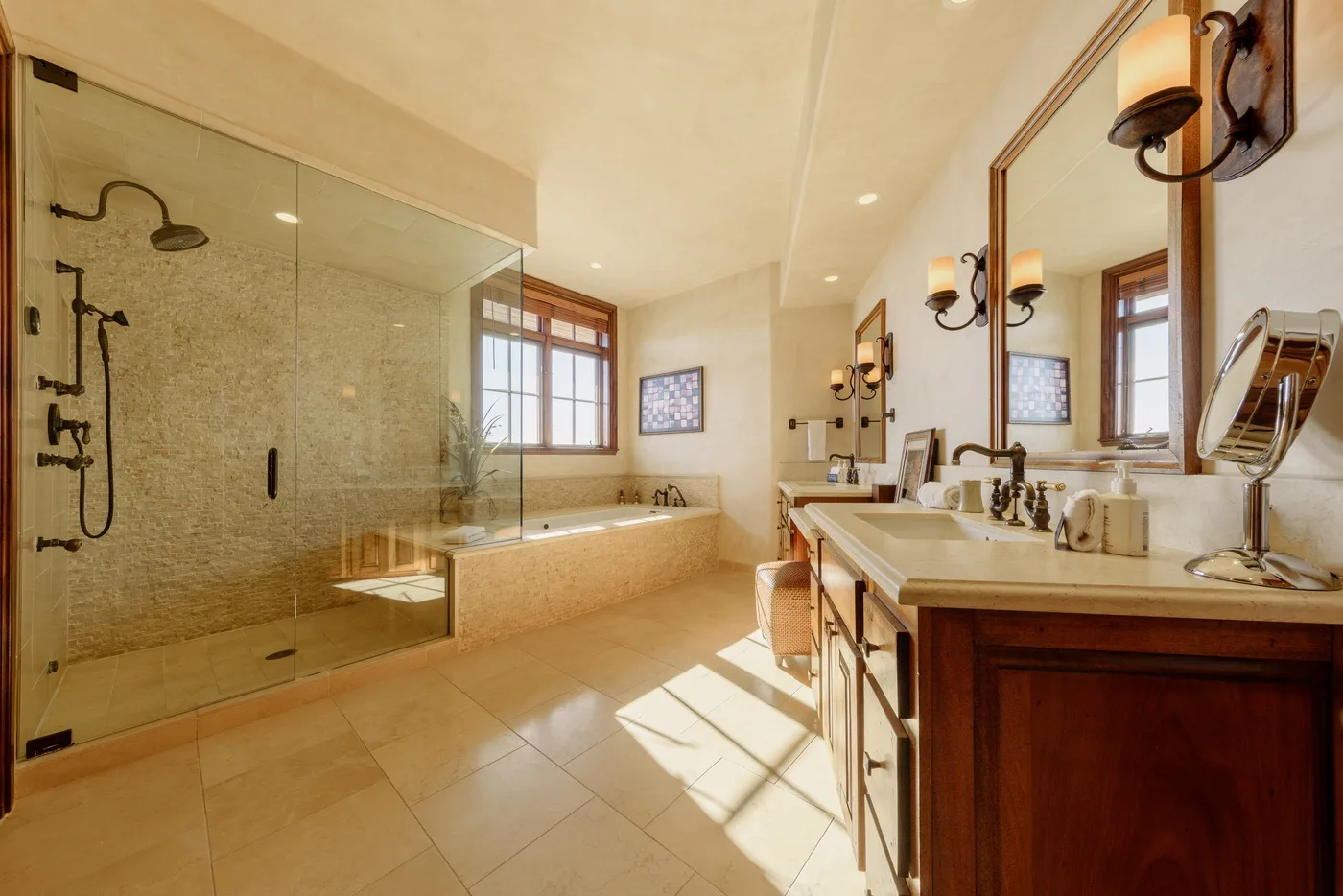 A spacious bathroom with a glass shower, bathtub, and long vanity.