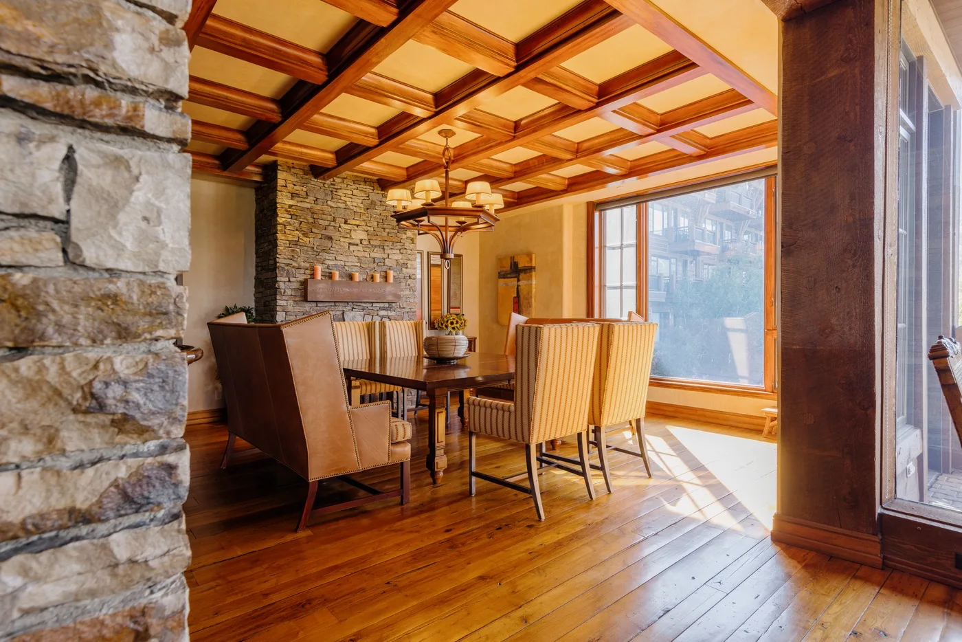 Comedor con una mesa y sillas junto a grandes ventanales.