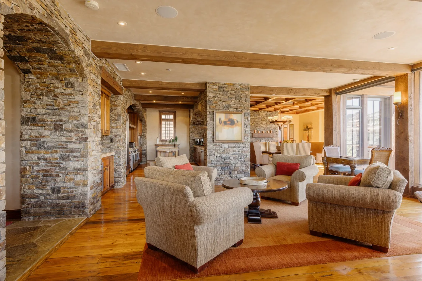 A spacious living room with seating arranged around a coffee table.