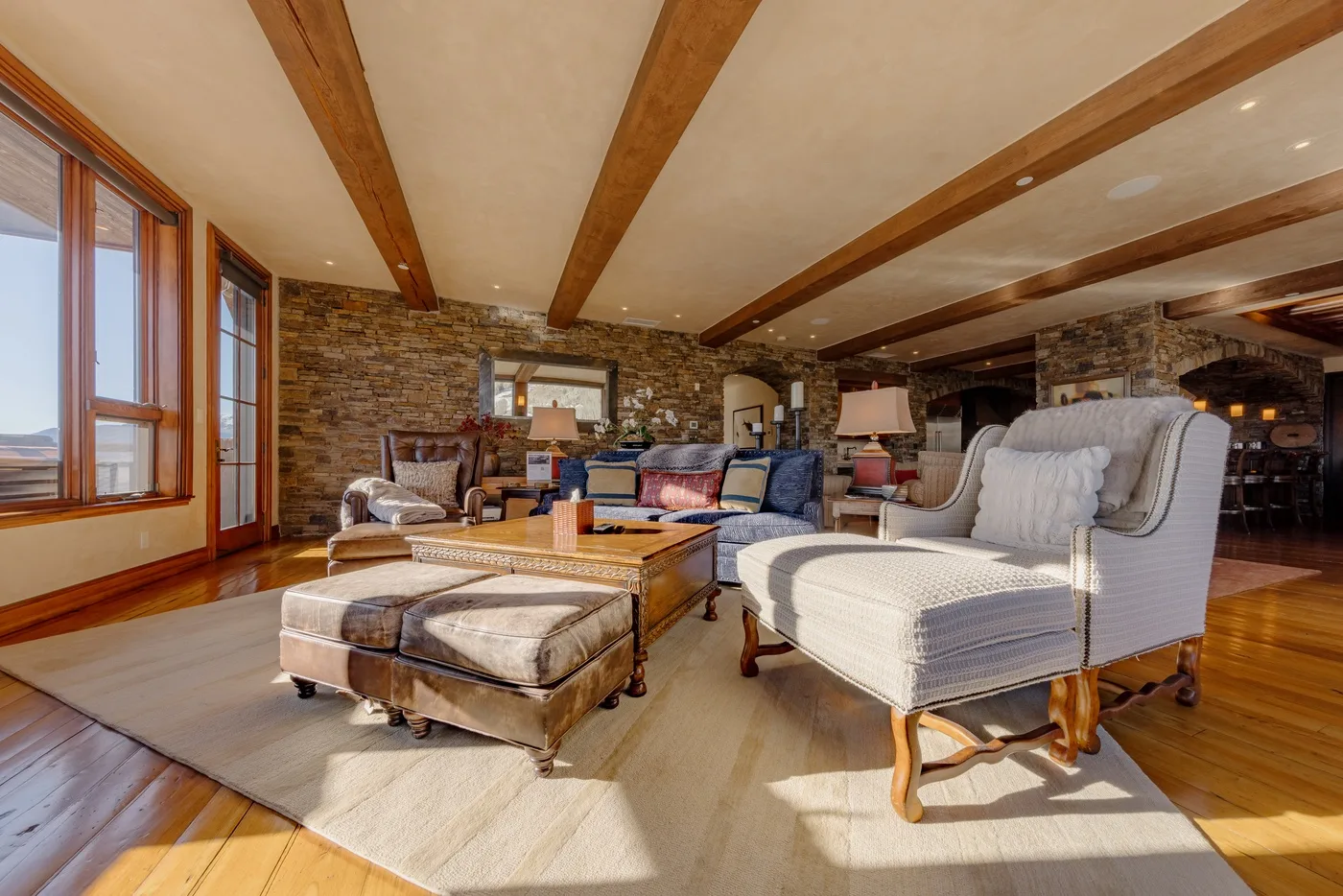 A spacious living room with seating arranged around a low wooden table.