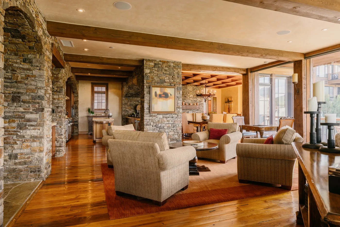 A stone-accented living room with seating arranged around a rug.