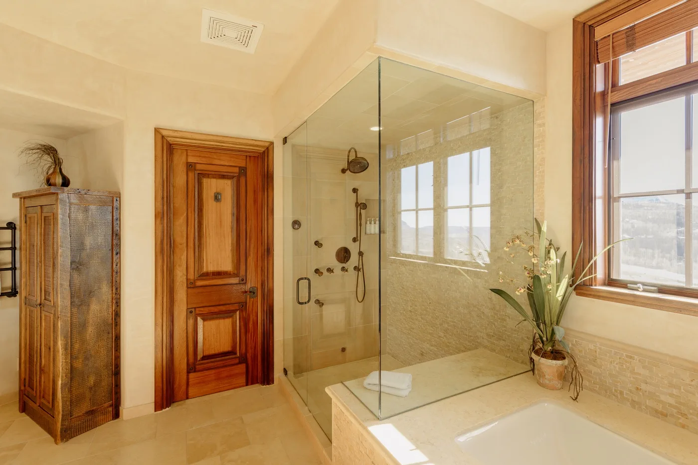 Un baño con ducha de vidrio, bañera y ventana.