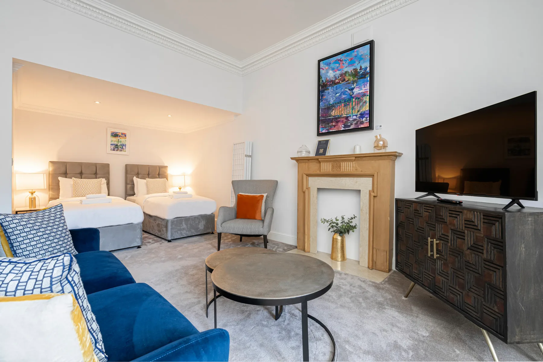 Una sala de estar con asientos, un televisor y una chimenea.