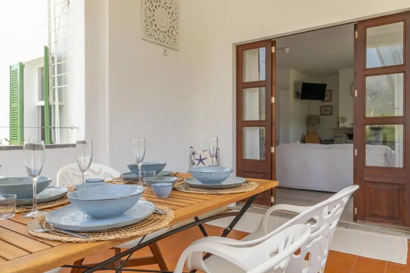 A dining table is set with blue dishes beside an open doorway.
