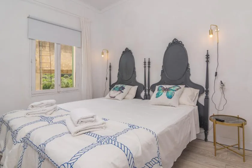 A bedroom with two beds dressed in white bedding with blue patterns.