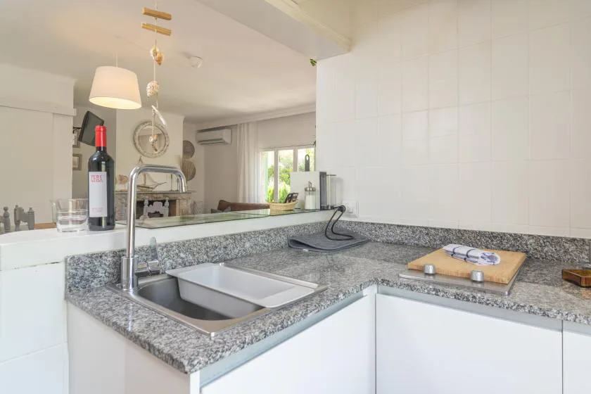 A bright kitchen with a stainless-steel sink set into a gray countertop.