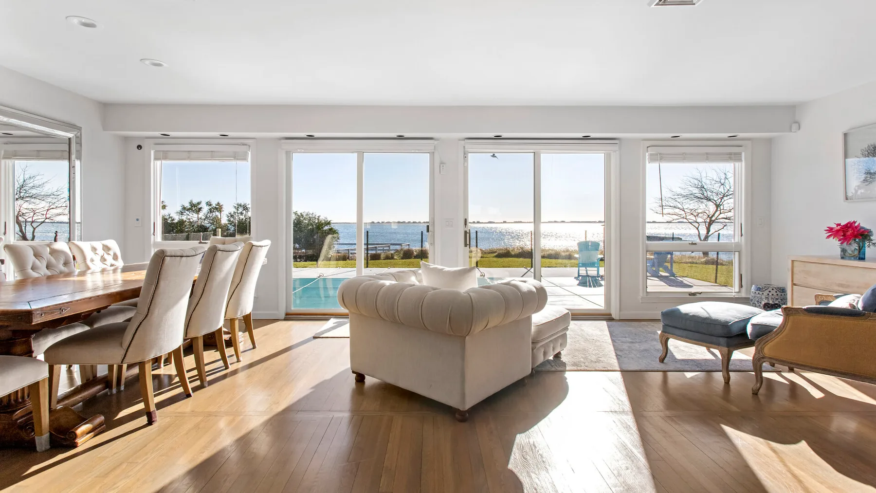 A bright living and dining area opens onto large windows overlooking the water.