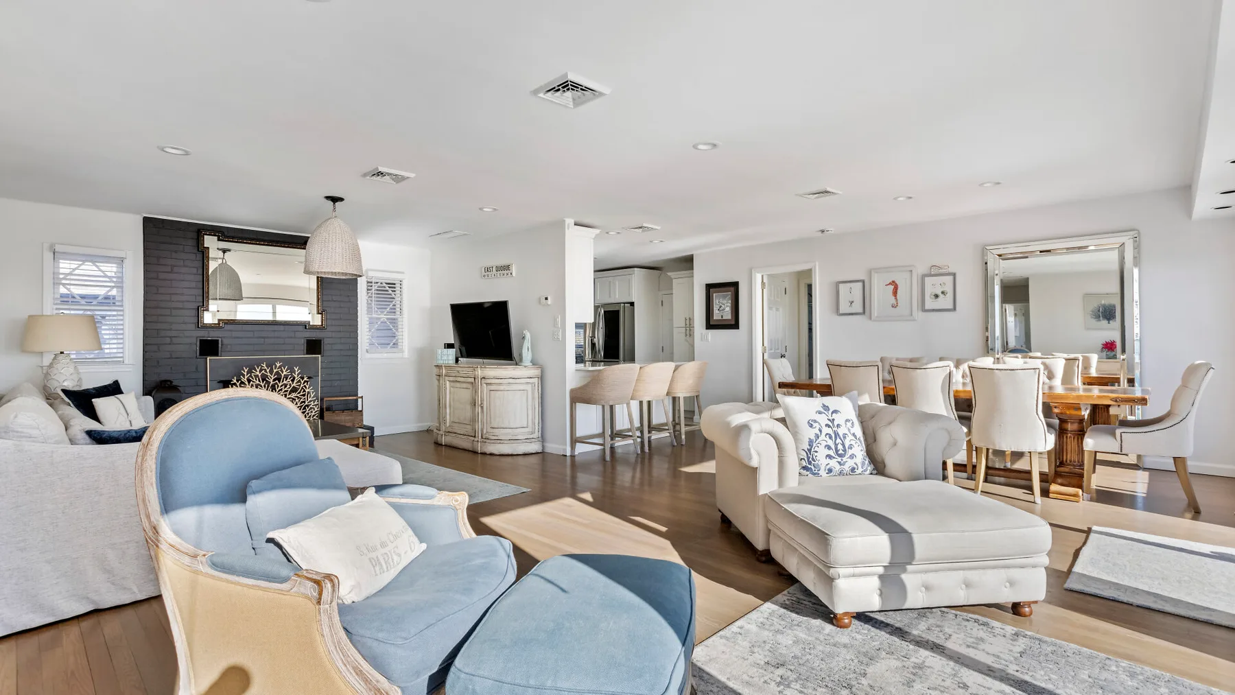 A bright open-plan living and dining area with pale seating and a dining table.