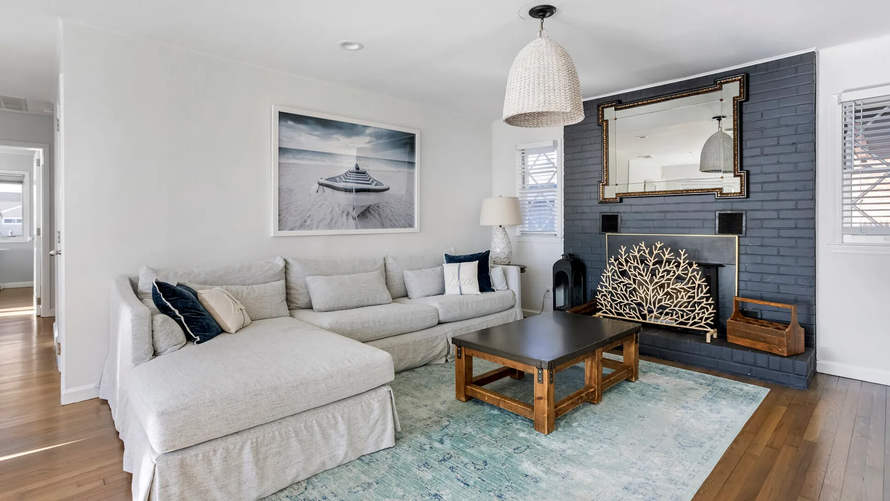 A living room with a sectional seating area, coffee table, and fireplace.