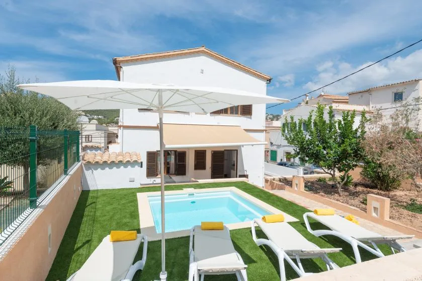 An outdoor pool area with lounge seating and a large shade umbrella.