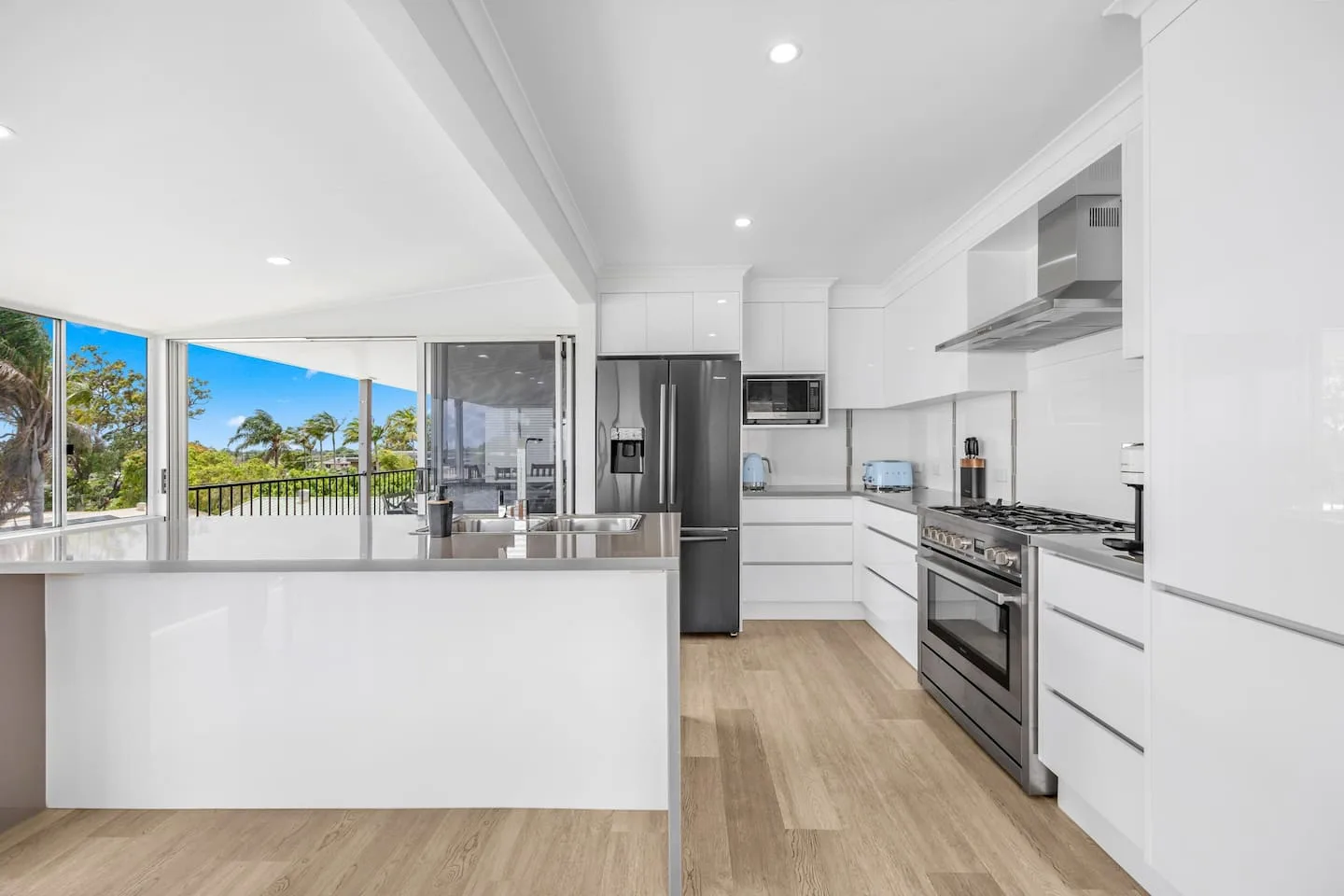 Una cocina luminosa con gabinetes blancos y un refrigerador de acero inoxidable.
