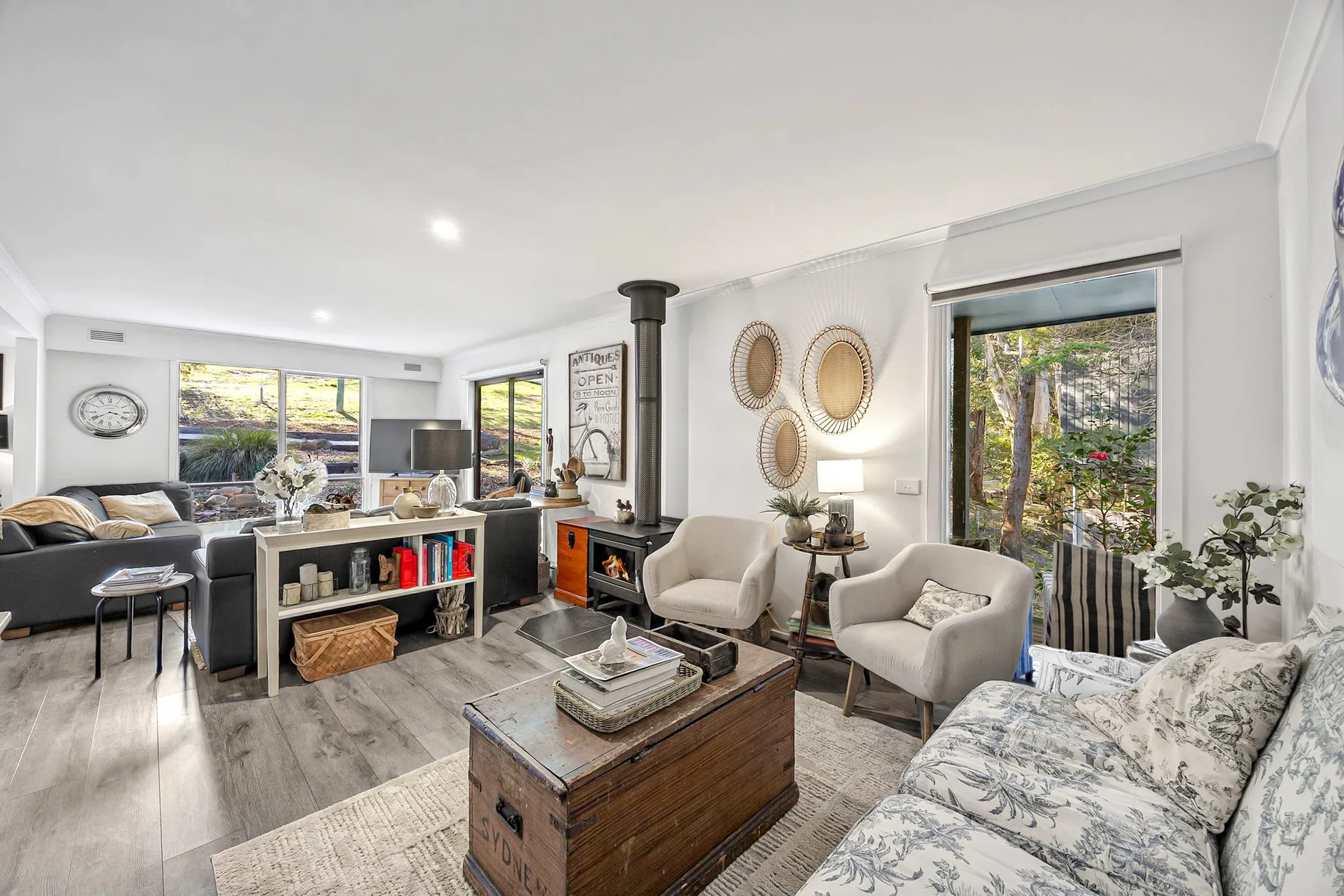 A bright living room with seating around a low wooden coffee table.