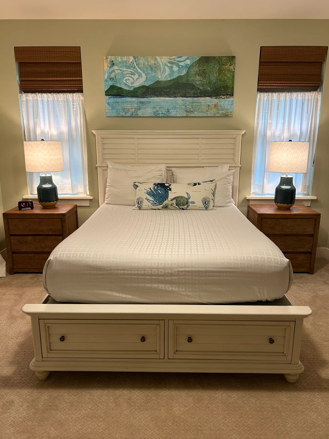 Un dormitorio con una cama tendida entre dos mesitas de noche.